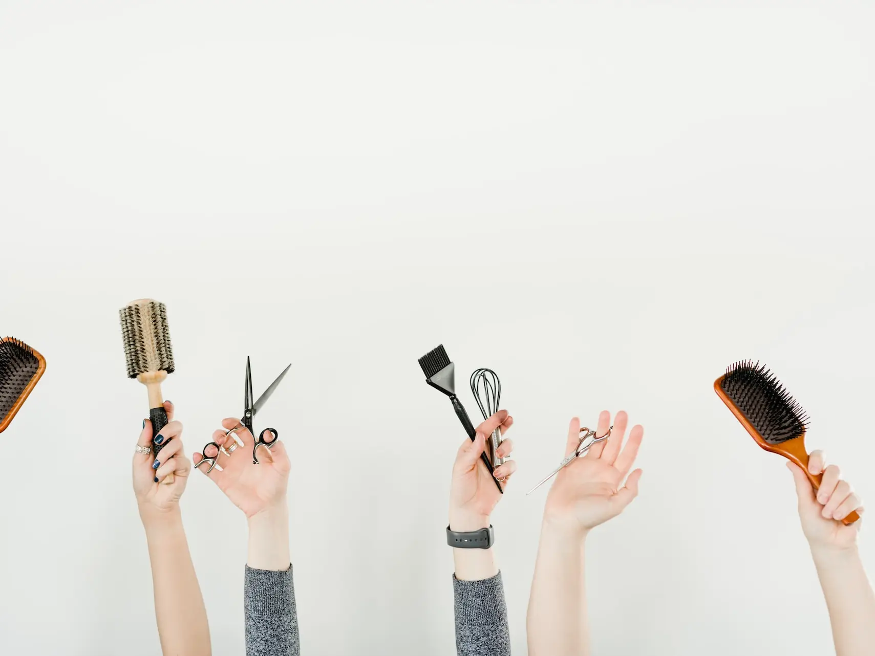 person holding silver and black hair brush